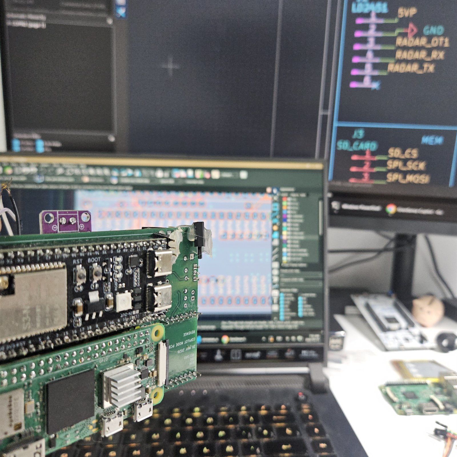 Several green SirenSense boards next to a laptop showing pin assignments for radar and for an SD card