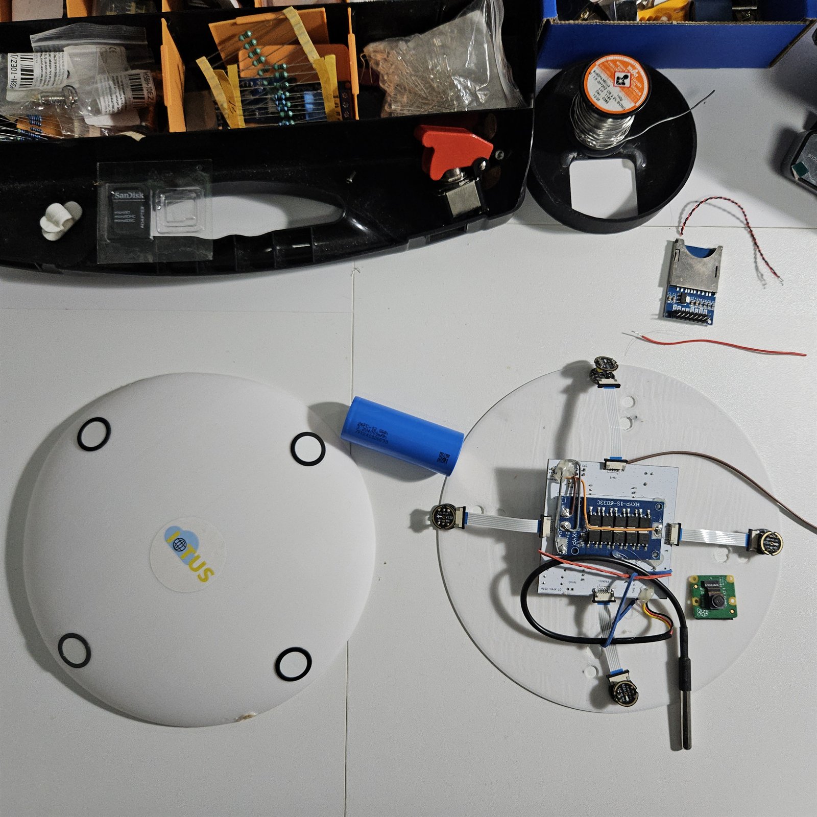 Two roof nodes side by side: the sealed unit with four round microphone ports in its lid, and an open unit showing the circuit board, battery, four microphone modules and satellite antenna