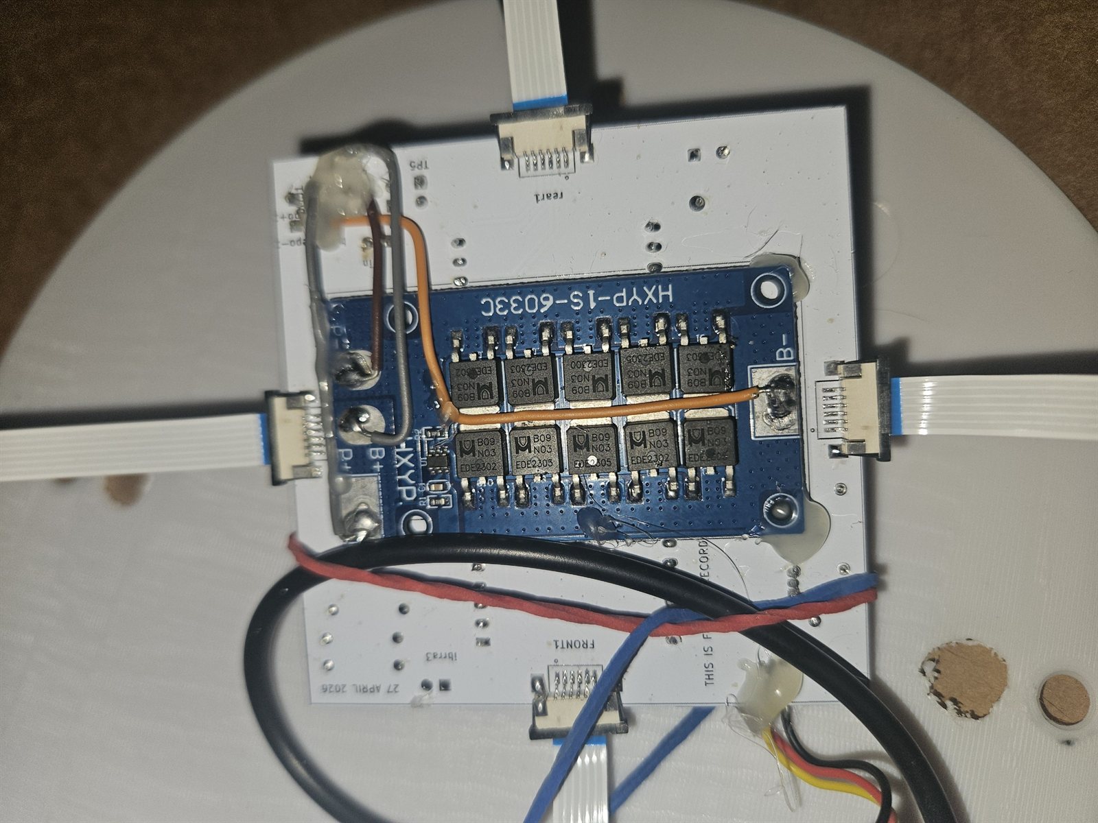 The interior of the roof node showing a blue HXYP-1S-60330 battery protection board with NCE3080K transistors and ribbon cables